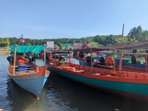 Two wooden Cambodian long boats on the water 