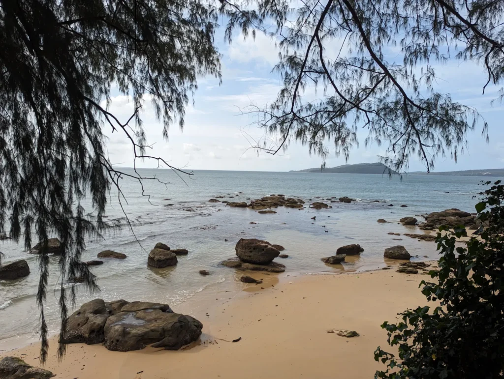 A beach on a quiet beach with large rocks.