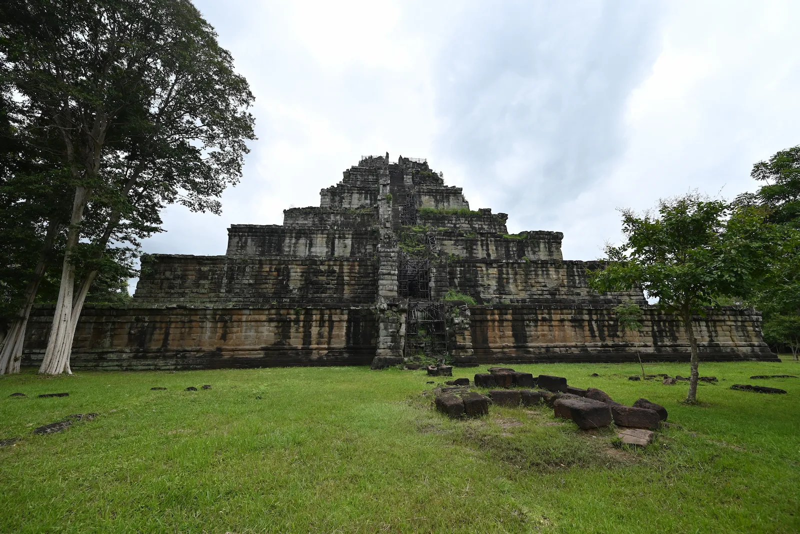 The Koh Ker pyramid temple (Prasat Thom) in Cambodia during the rainy season, with wet laterite stone and cloudy skies