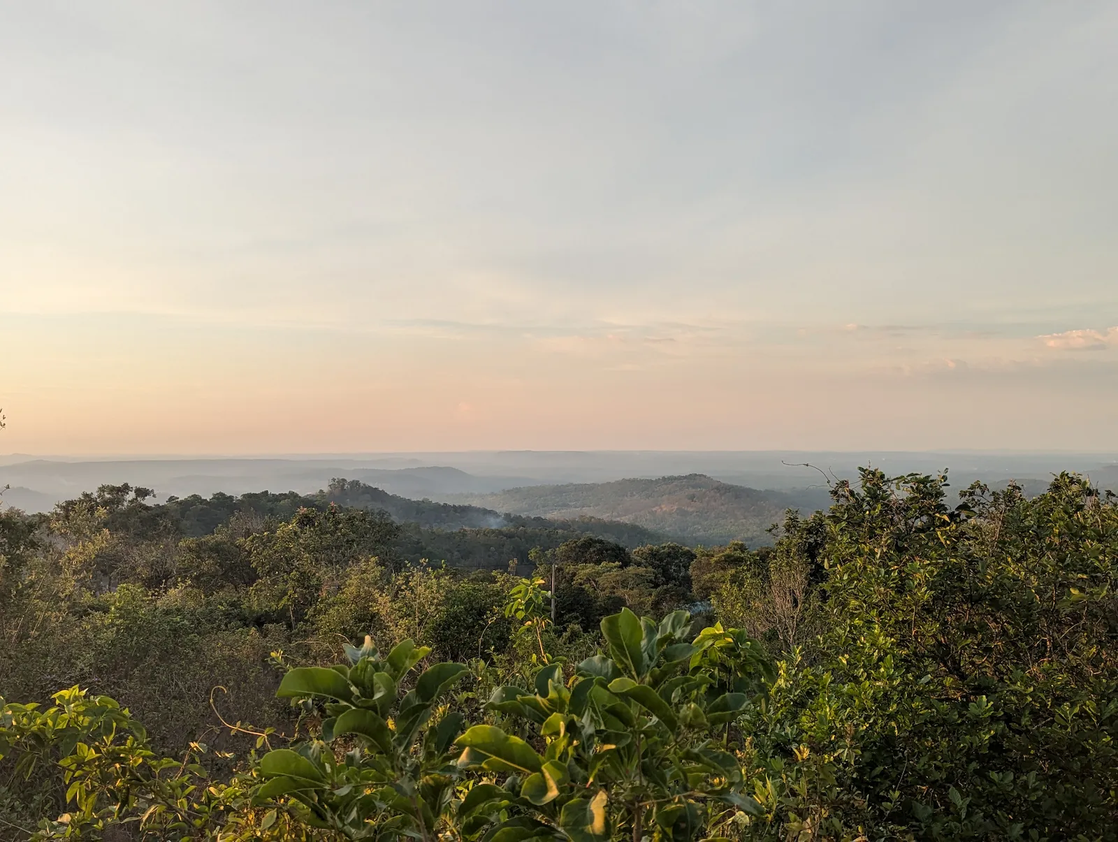Green forest-covered hills stretching across the landscape from the Sea Forest viewpoint in Mondulkiri.