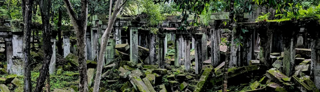 Moss-covered temple ruins at Beng Mealea surrounded by jungle vegetation.