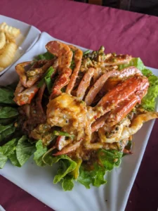 Cooked crab sits on a bed of lettuce. It is smothered in curry sauce.