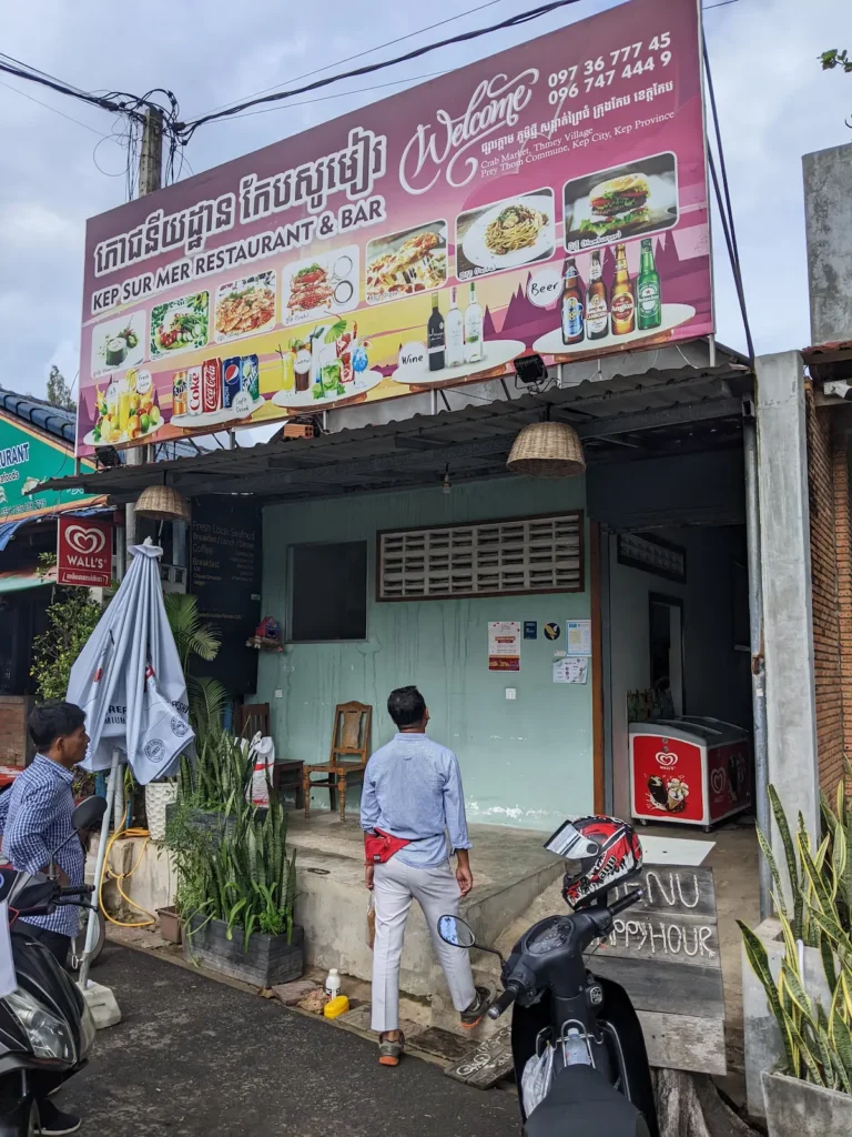 Kep Ser Mur resturant with motorbikes out the front and two people walking in the door.