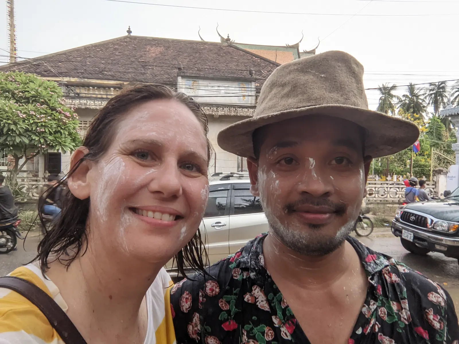 Mel and Nehru celebrating Khmer New Year. They are both wet and have white powder on their faces.
