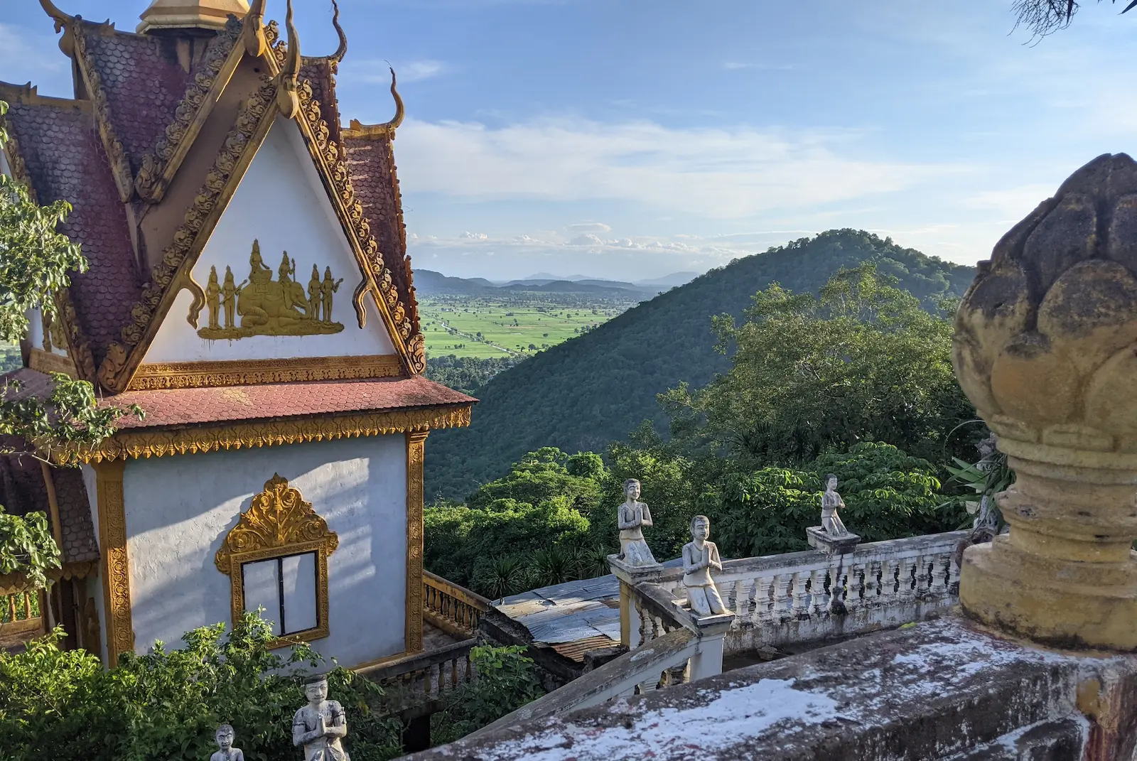 Temple building on Mount Sampov with the green rice fields in the background.