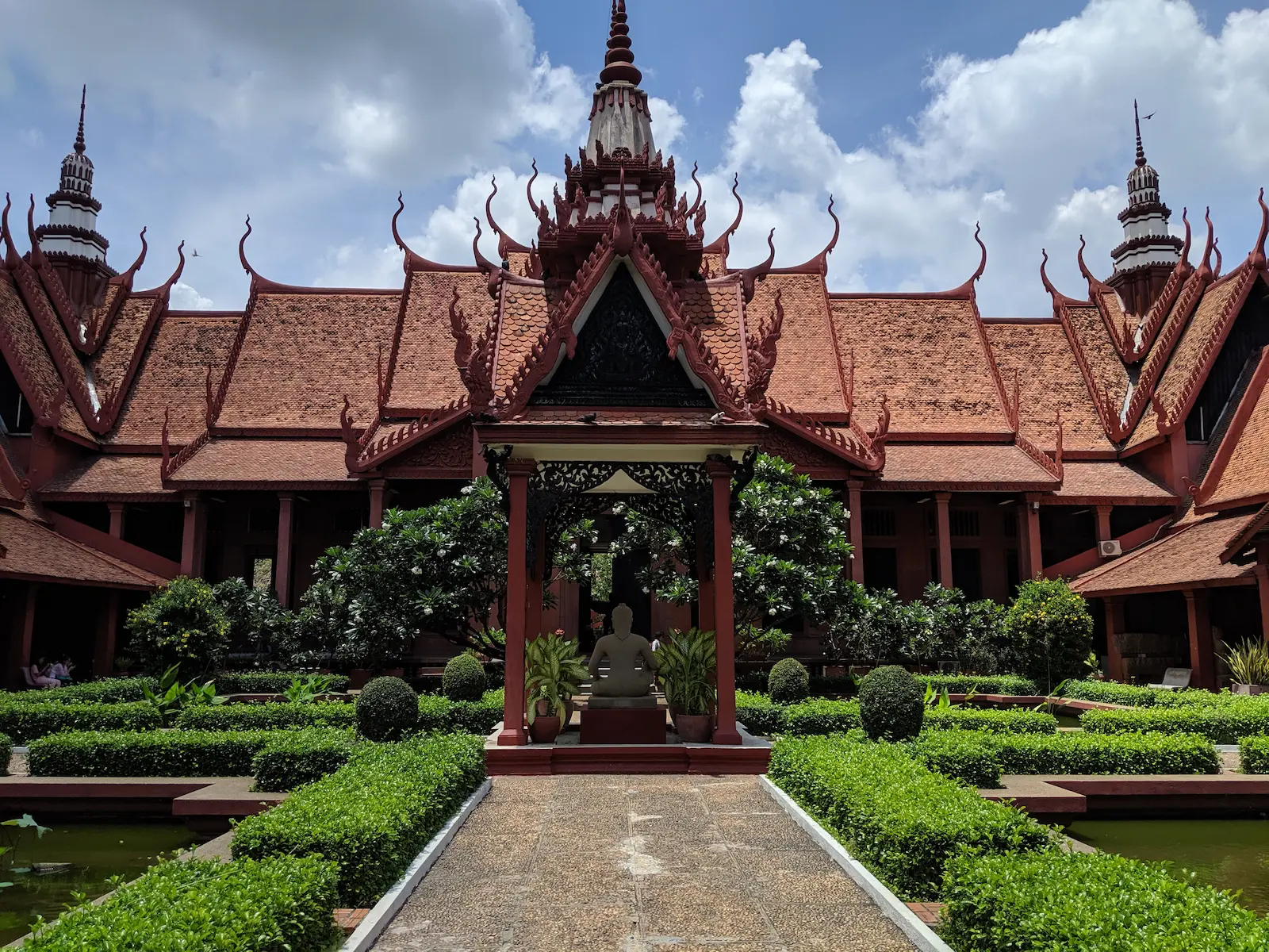 A concrete path leads to the National Museum. The roof is red with ornate corners.