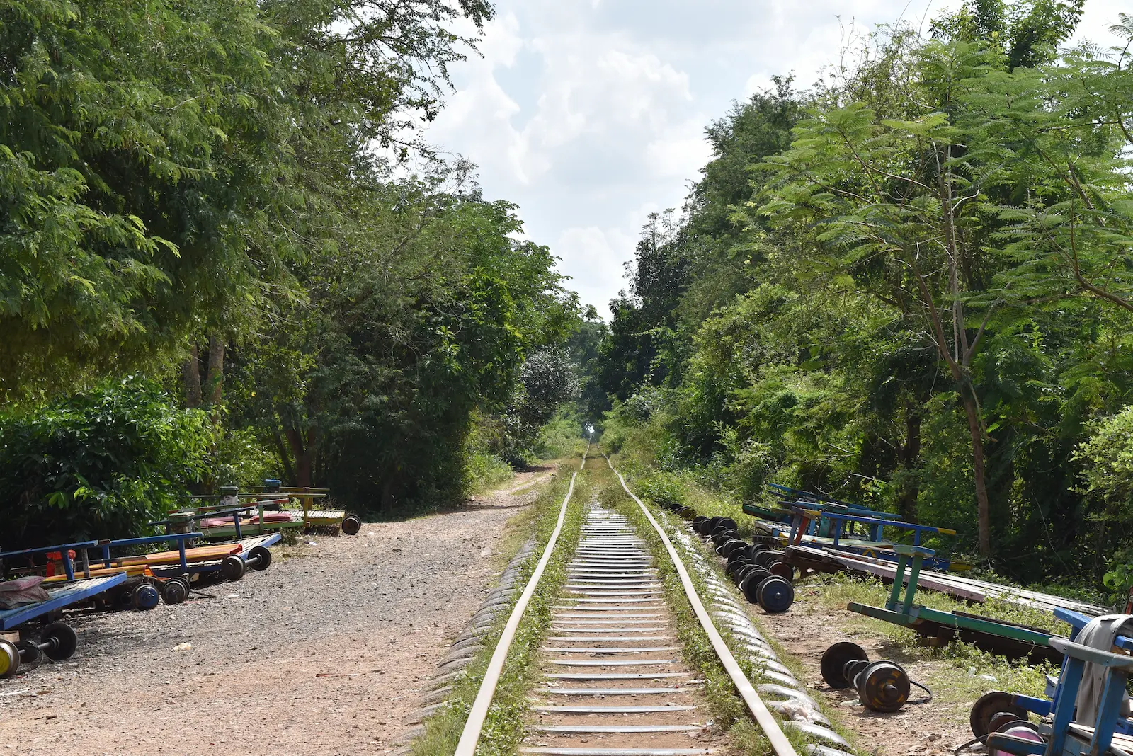 Crooked train tracks with axles lying nearby.