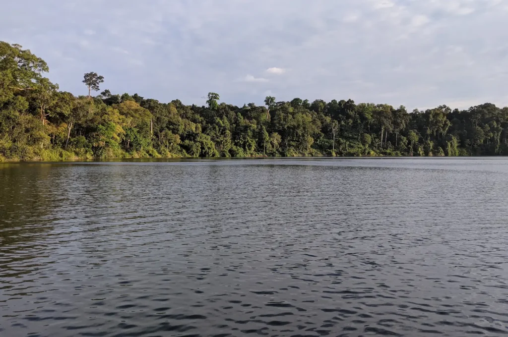 A clear lake Yeak Laom surrounded by forest.