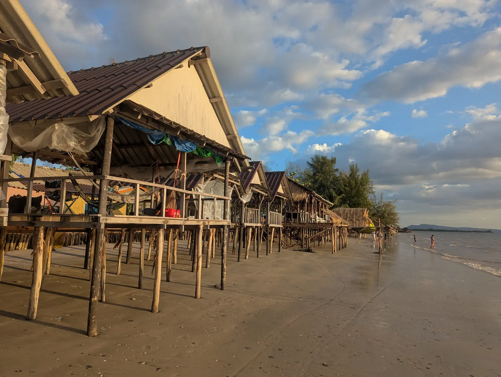 Bak Khlong beach with wooden huts on the left and the waves crashing on the right.