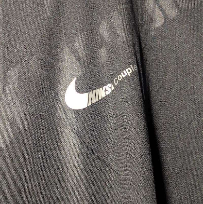 Silver Nike swoosh on a grey t shirt with NIKS written on it