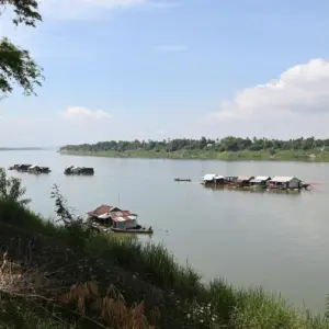 Small houses floating in a river as part of the Vietnamese Floating Village.