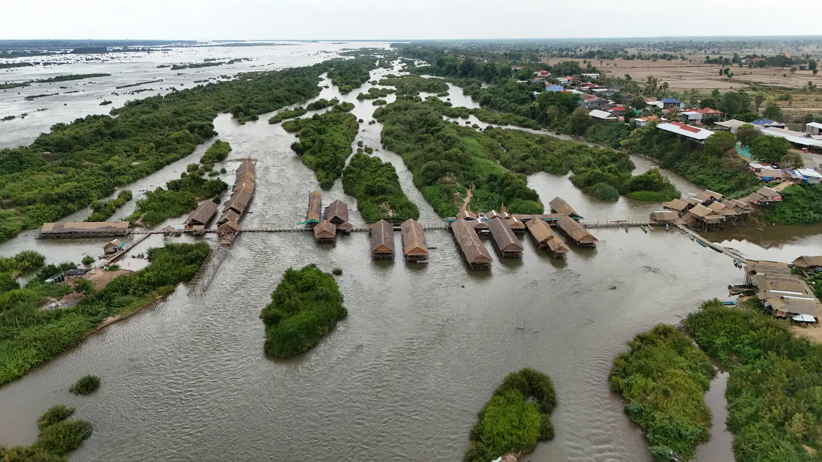 Drone shot of Kampi Rapids with long huts connected with bridges.