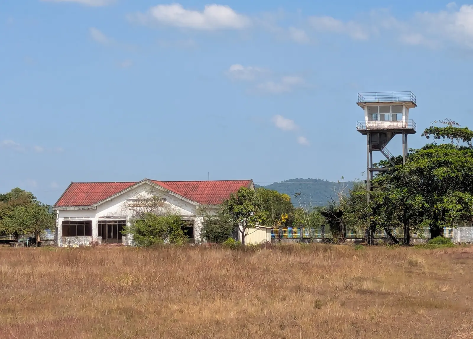 White terminal building with red roof and a tower next to it