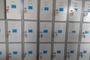 A row of lockers with keys and names on them; London, Seoul, Battambang