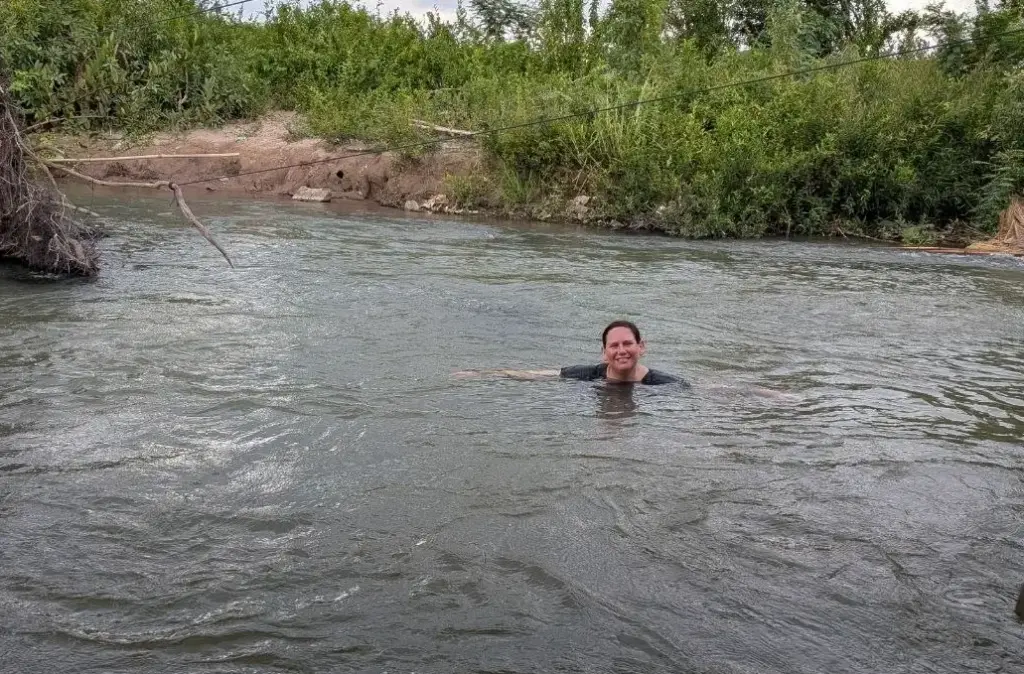 Mel swimming in Mekong River with the bank in the background.