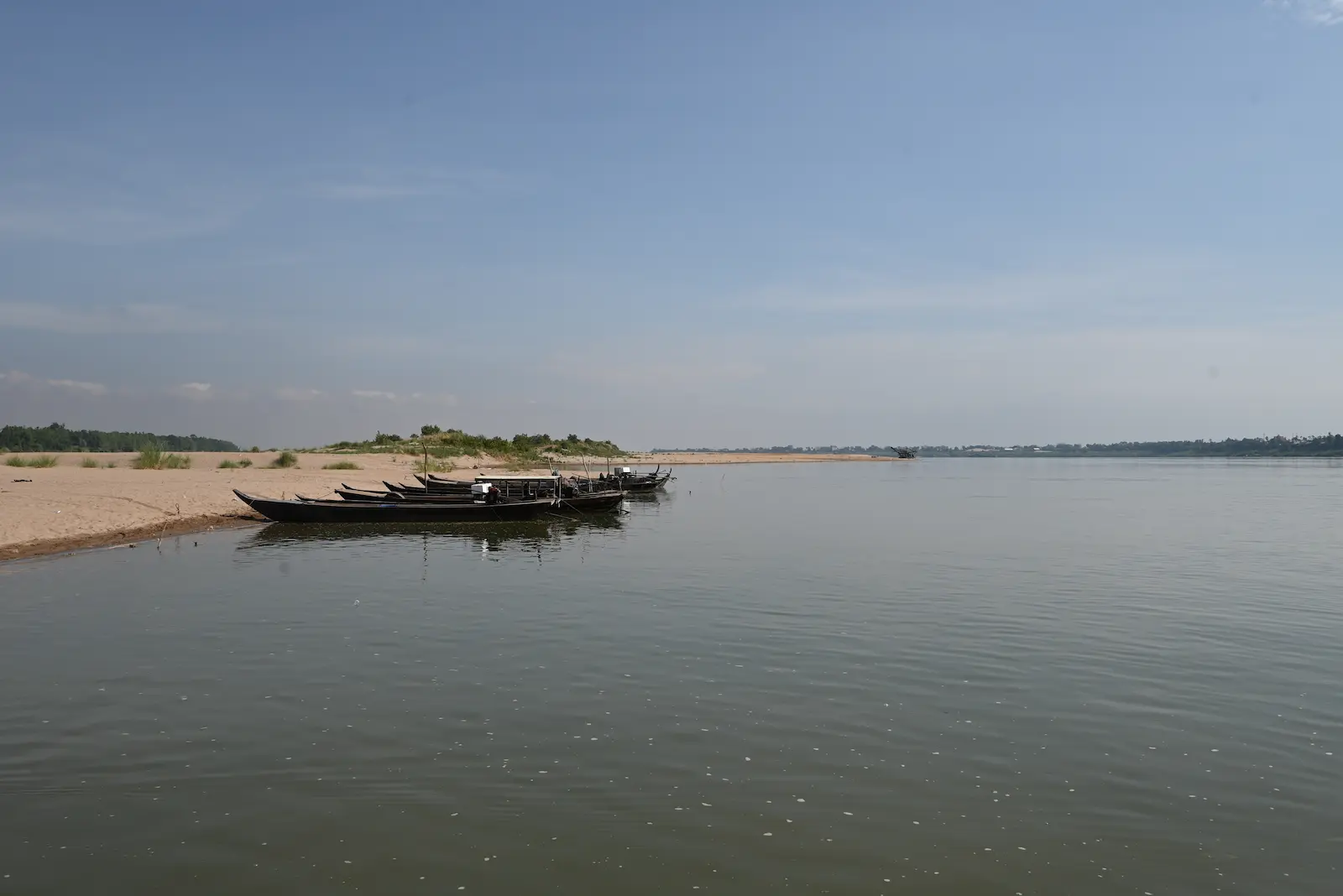 A boat sits on a sandbar along the Mekong River