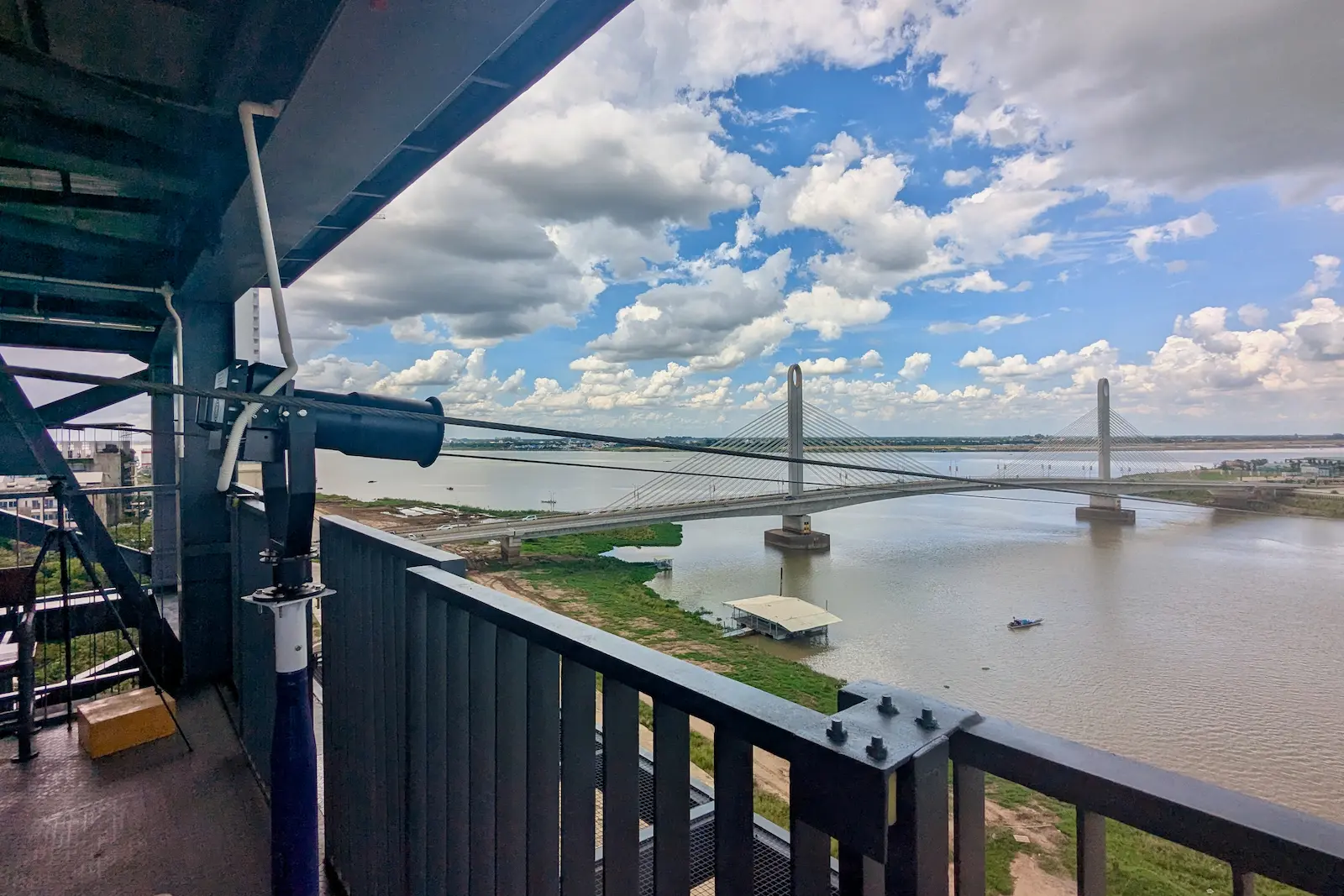 View from a platform overlooking a river with a bridge.