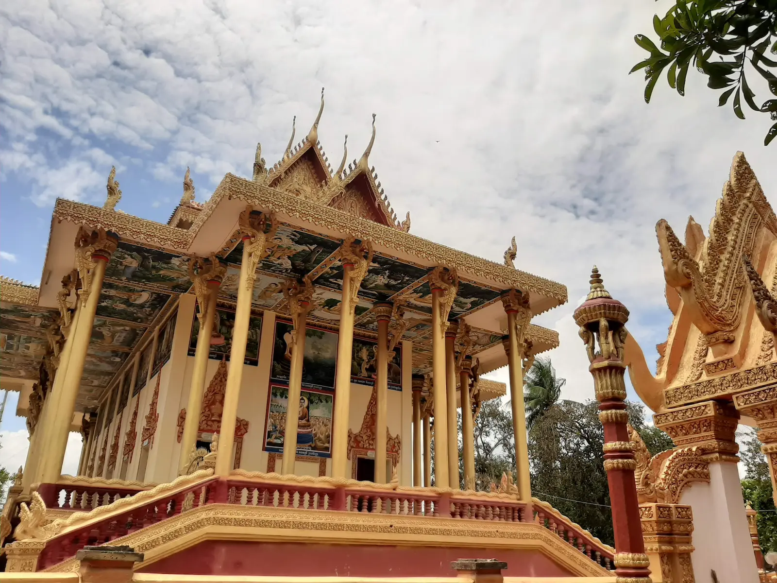 Colourful modern Buddhist pagoda at Ek Phnom Temple in Battambang, with traditional Khmer architecture and an ornate roof.