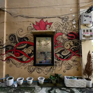 Red and black street art around a window in Battambang.